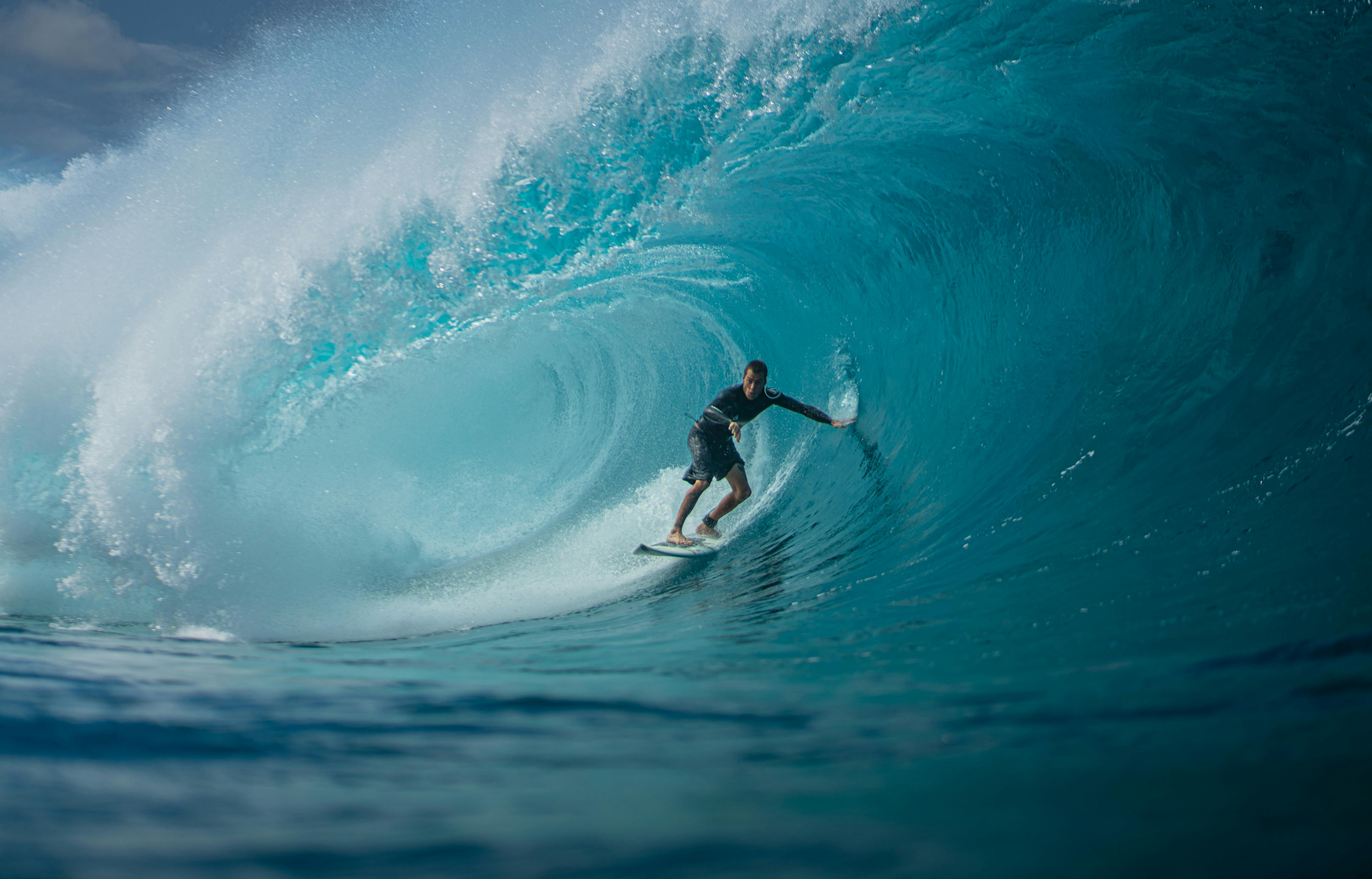Surfer riding a massive turquoise wave